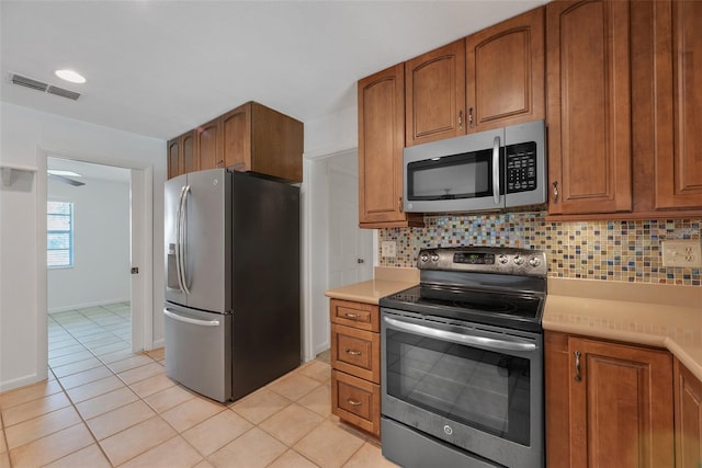 kitchen with tasteful backsplash, appliances with stainless steel finishes, and light tile patterned floors