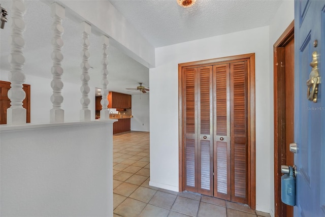 hallway featuring light tile patterned flooring and a textured ceiling