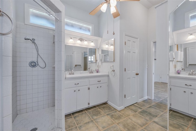 bathroom featuring a tile shower, vanity, a towering ceiling, and ceiling fan