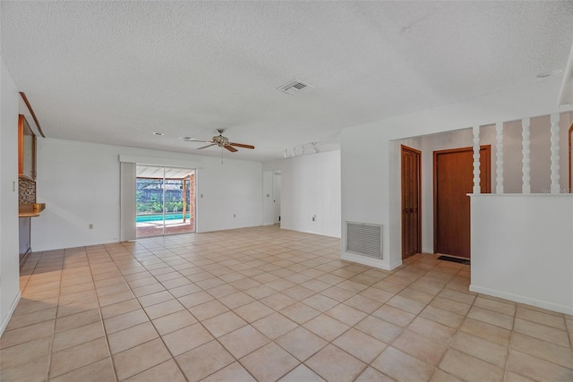 tiled empty room with a textured ceiling and ceiling fan