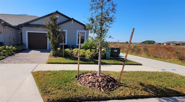 ranch-style house with a garage and a front lawn