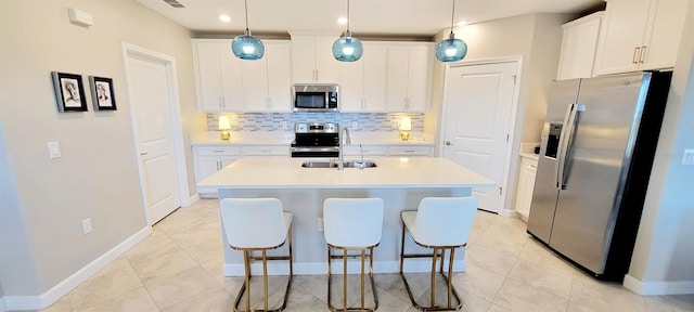 kitchen with decorative light fixtures, white cabinets, and stainless steel appliances