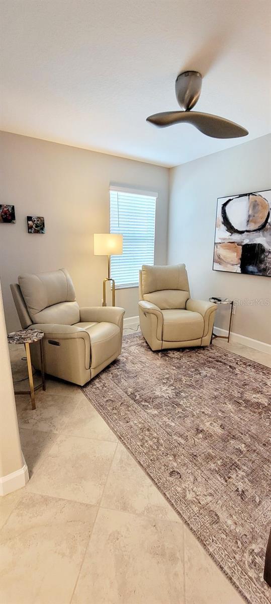 tiled living room with ceiling fan