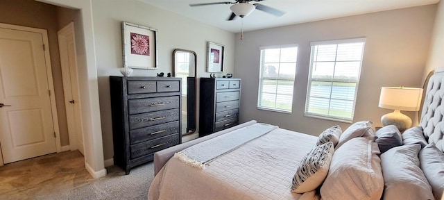 bedroom featuring ceiling fan, light colored carpet, and multiple windows