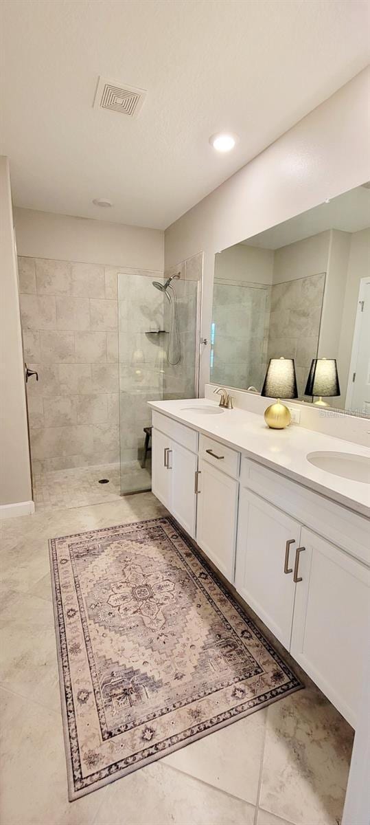 bathroom featuring vanity and tiled shower