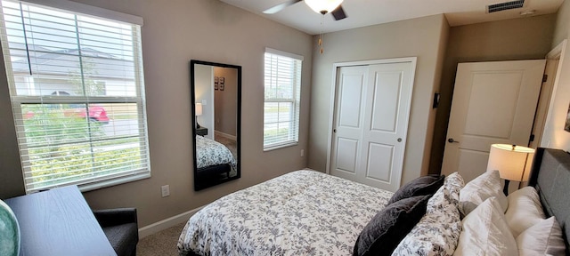 bedroom with ceiling fan, multiple windows, and a closet