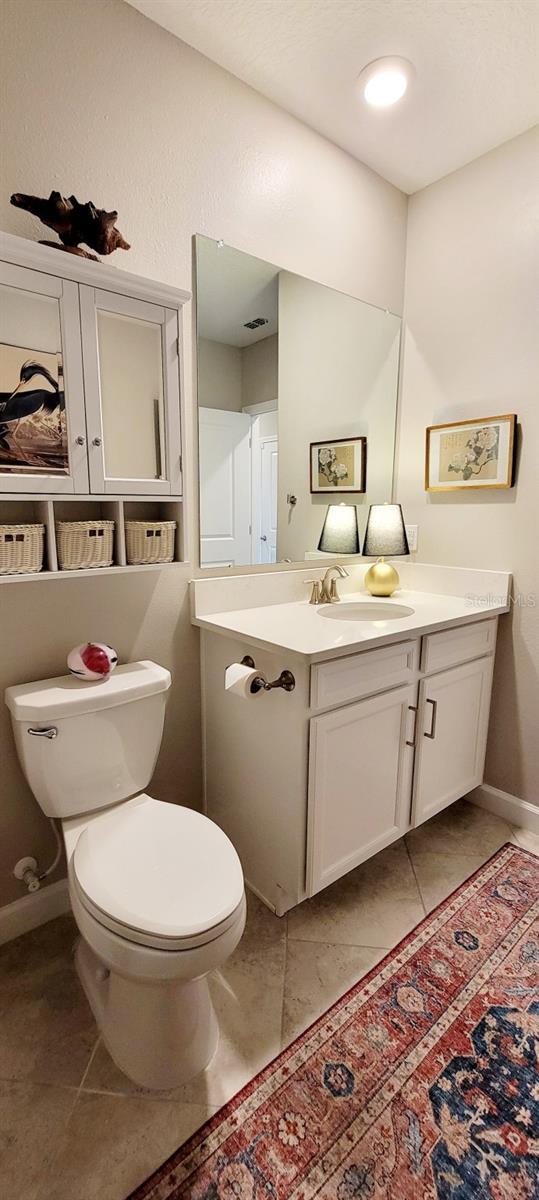 bathroom featuring toilet, vanity, and tile patterned floors