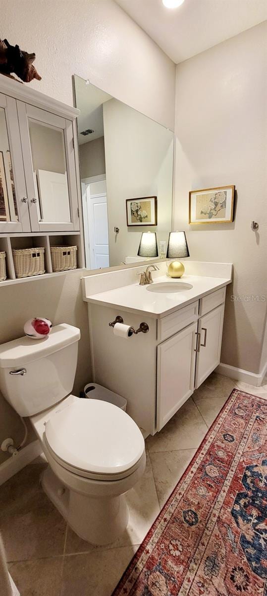 bathroom featuring toilet, vanity, and tile patterned flooring