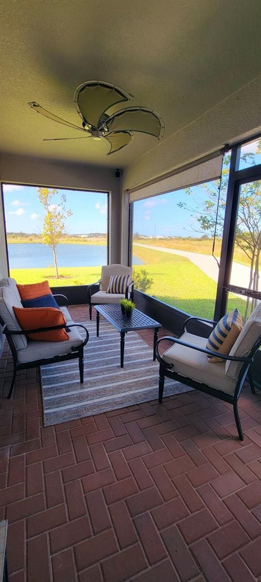 sunroom / solarium featuring a water view