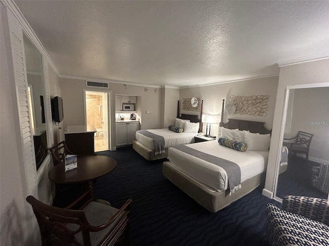 bedroom featuring ensuite bath, dark carpet, crown molding, and a textured ceiling