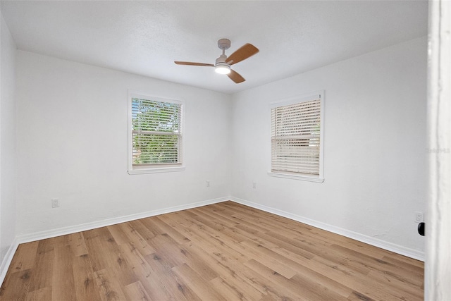 empty room with ceiling fan and light hardwood / wood-style flooring