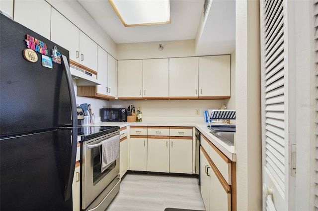 kitchen with sink, light wood-type flooring, white cabinetry, and black appliances