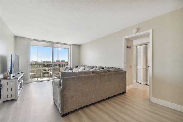 living room featuring a textured ceiling and light hardwood / wood-style floors