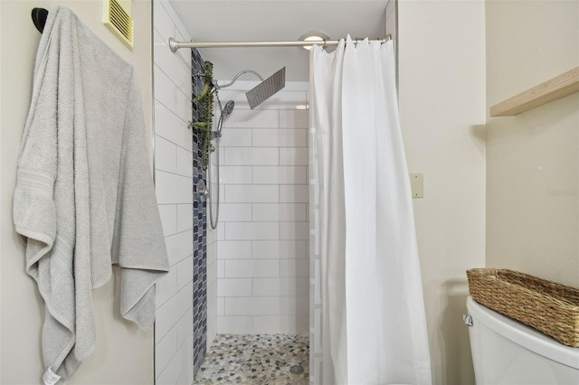 bathroom featuring a shower with shower curtain and toilet