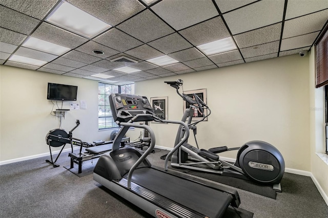 workout area with carpet flooring and a paneled ceiling