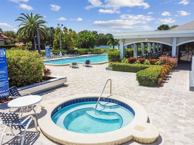 view of swimming pool with a patio and a hot tub