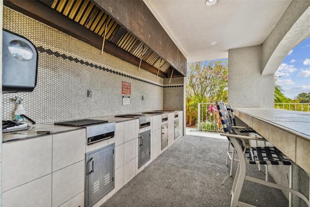 view of patio featuring exterior bar and exterior kitchen