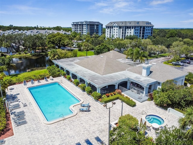 view of pool with a water view and a patio