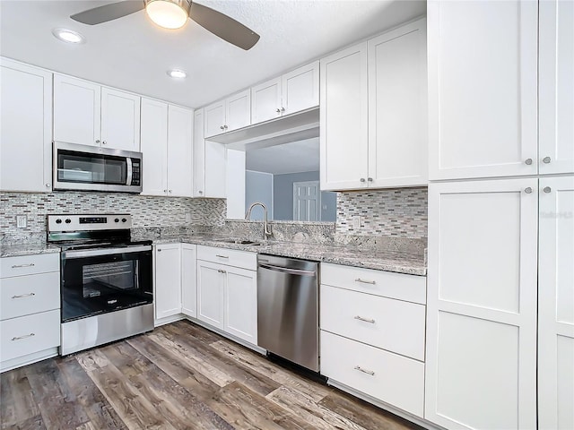 kitchen featuring white cabinets, appliances with stainless steel finishes, and dark hardwood / wood-style flooring