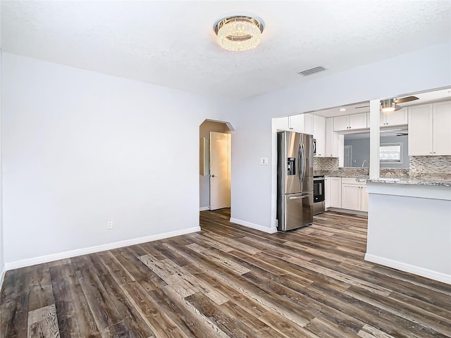 kitchen featuring white cabinetry, tasteful backsplash, stainless steel refrigerator with ice dispenser, ceiling fan, and dark wood-type flooring