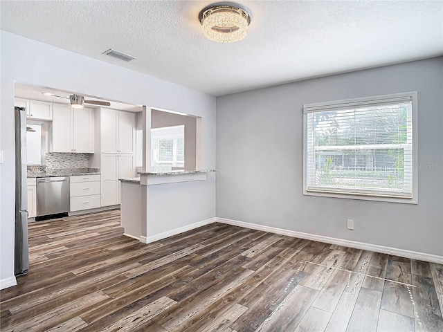 kitchen featuring white cabinets, appliances with stainless steel finishes, dark hardwood / wood-style floors, and plenty of natural light