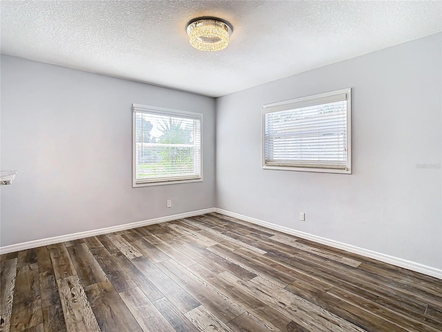 unfurnished room with dark wood-type flooring and a textured ceiling