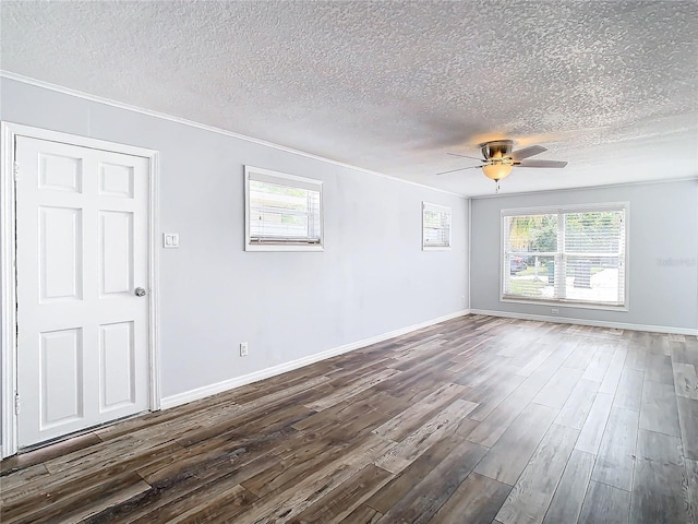 empty room with plenty of natural light, a textured ceiling, and dark hardwood / wood-style flooring