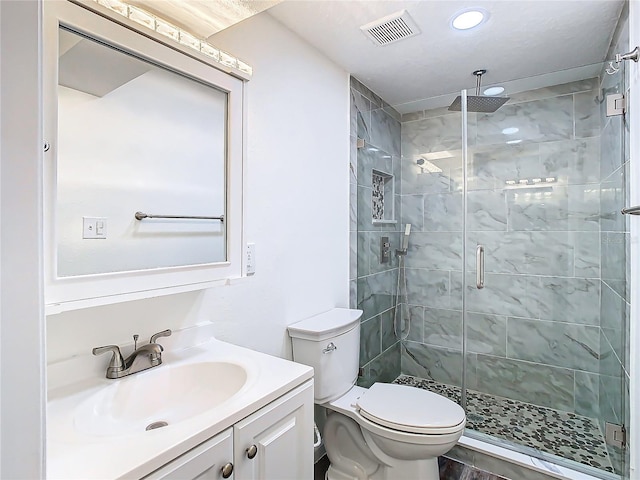 bathroom featuring vanity, toilet, and a shower with door