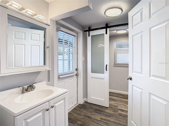 bathroom featuring vanity, a textured ceiling, hardwood / wood-style flooring, and plenty of natural light