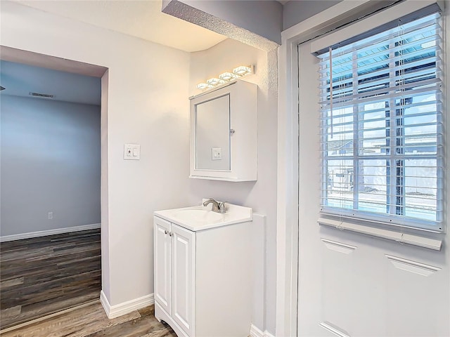 bathroom with vanity, a wealth of natural light, and hardwood / wood-style floors