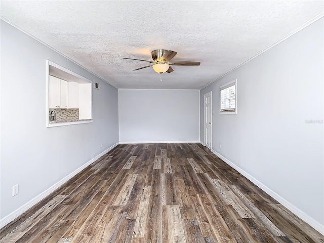 empty room featuring dark wood-type flooring, ceiling fan, a textured ceiling, and crown molding