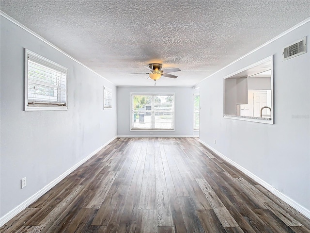 unfurnished room featuring ceiling fan, plenty of natural light, a textured ceiling, and dark hardwood / wood-style flooring