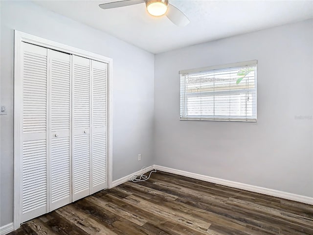 unfurnished bedroom featuring dark wood-type flooring, ceiling fan, and a closet