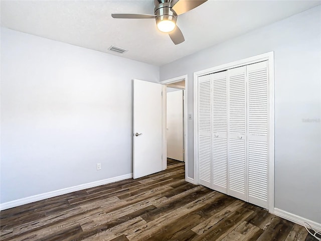 unfurnished bedroom featuring dark wood-type flooring, ceiling fan, and a closet