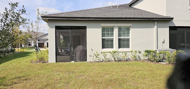 rear view of house with a sunroom and a yard