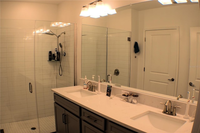 bathroom featuring a shower with shower door and vanity