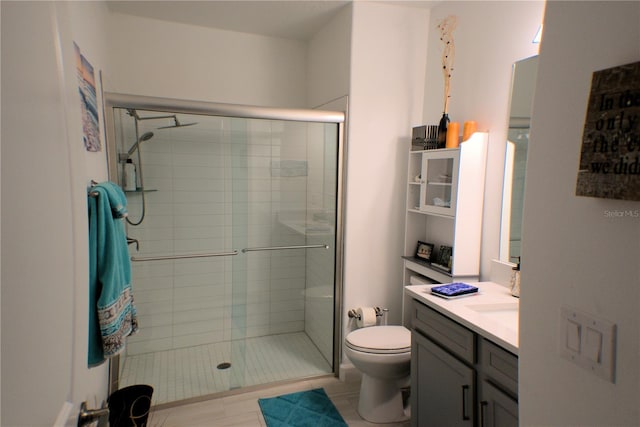 bathroom with toilet, an enclosed shower, and vanity