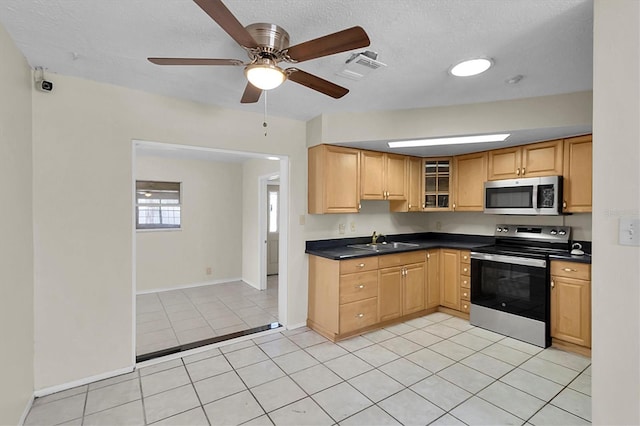 kitchen with stainless steel appliances, a textured ceiling, light tile patterned floors, sink, and ceiling fan