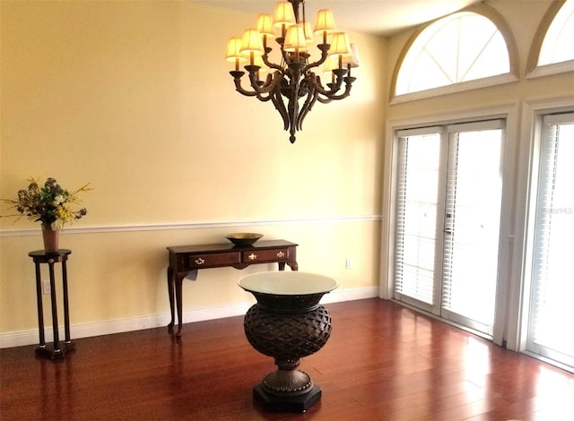 interior space with dark wood-type flooring and an inviting chandelier