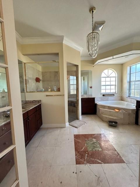 bathroom featuring tile patterned floors, vanity, ornamental molding, and independent shower and bath