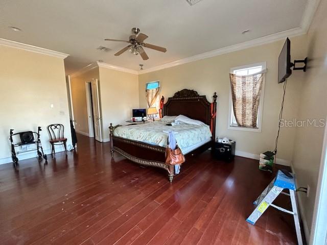 bedroom featuring ceiling fan, crown molding, and dark wood-type flooring