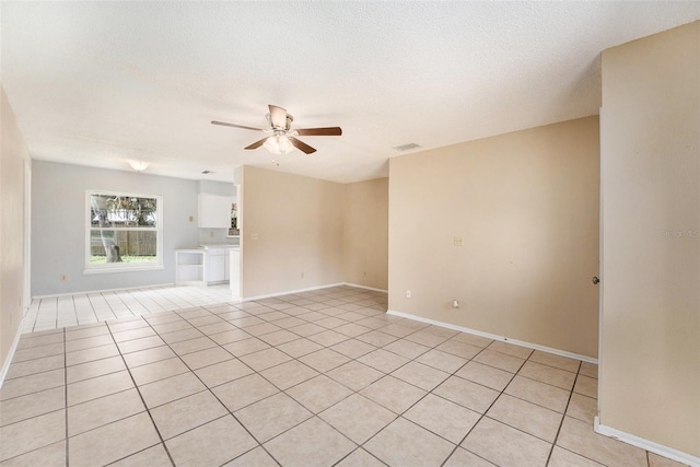 unfurnished living room with a textured ceiling, light tile patterned floors, and ceiling fan