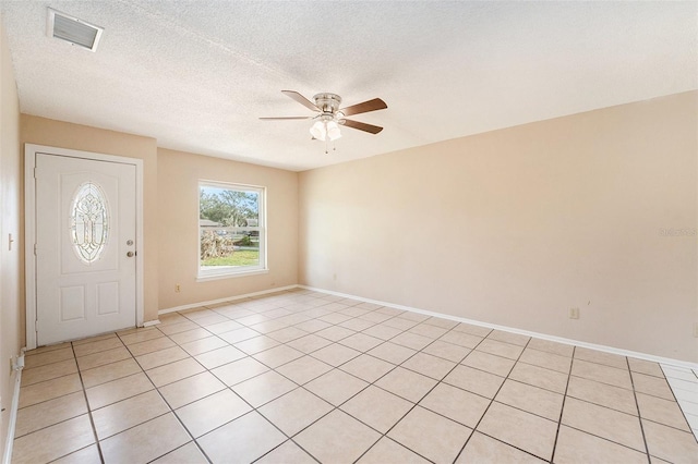 tiled entryway with a textured ceiling and ceiling fan