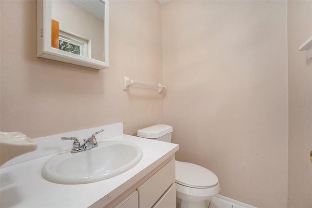 bathroom featuring toilet, vanity, and a textured ceiling