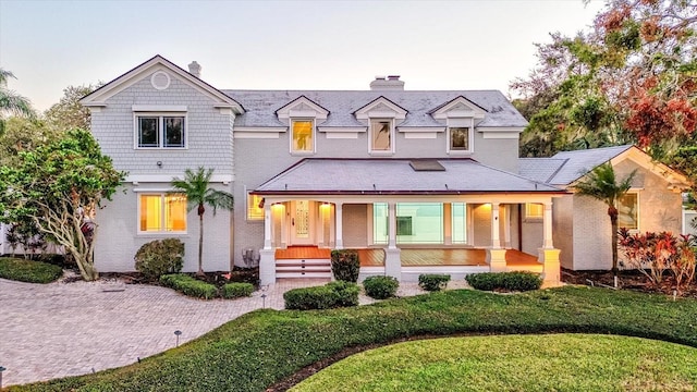 view of front of home featuring covered porch and a yard