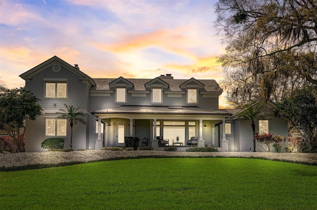 view of front of home featuring covered porch and a lawn