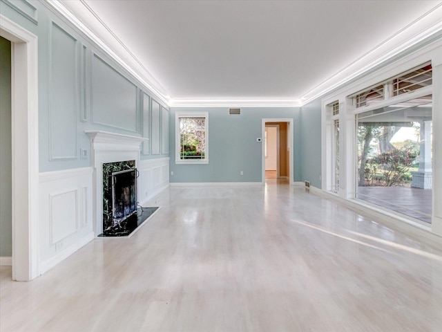 unfurnished living room featuring a high end fireplace and ornamental molding