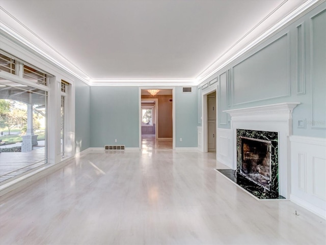 unfurnished living room with a fireplace, a wealth of natural light, and crown molding