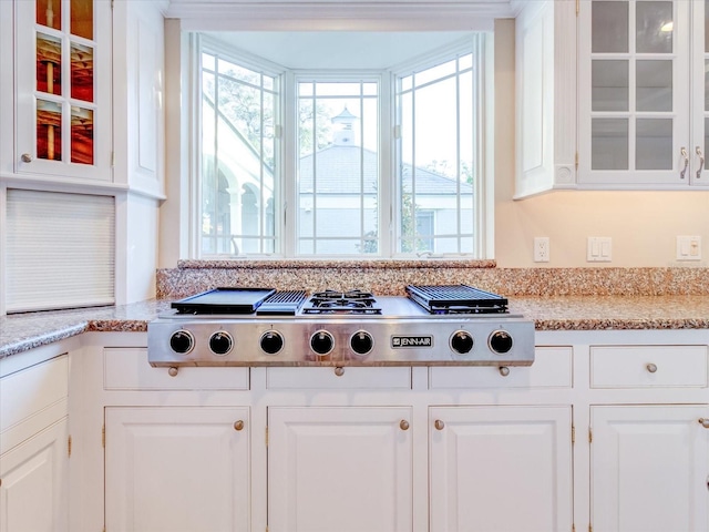 kitchen featuring white cabinets, stainless steel gas stovetop, and light stone countertops