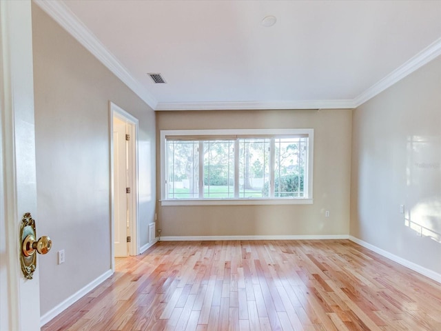 spare room featuring light hardwood / wood-style floors, a wealth of natural light, and ornamental molding